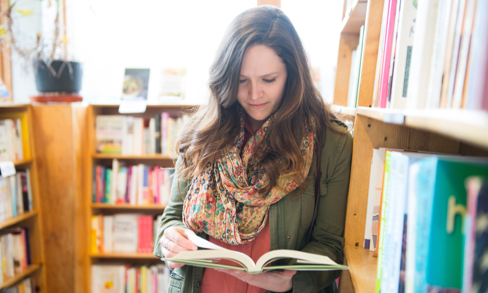 woman reading book in store