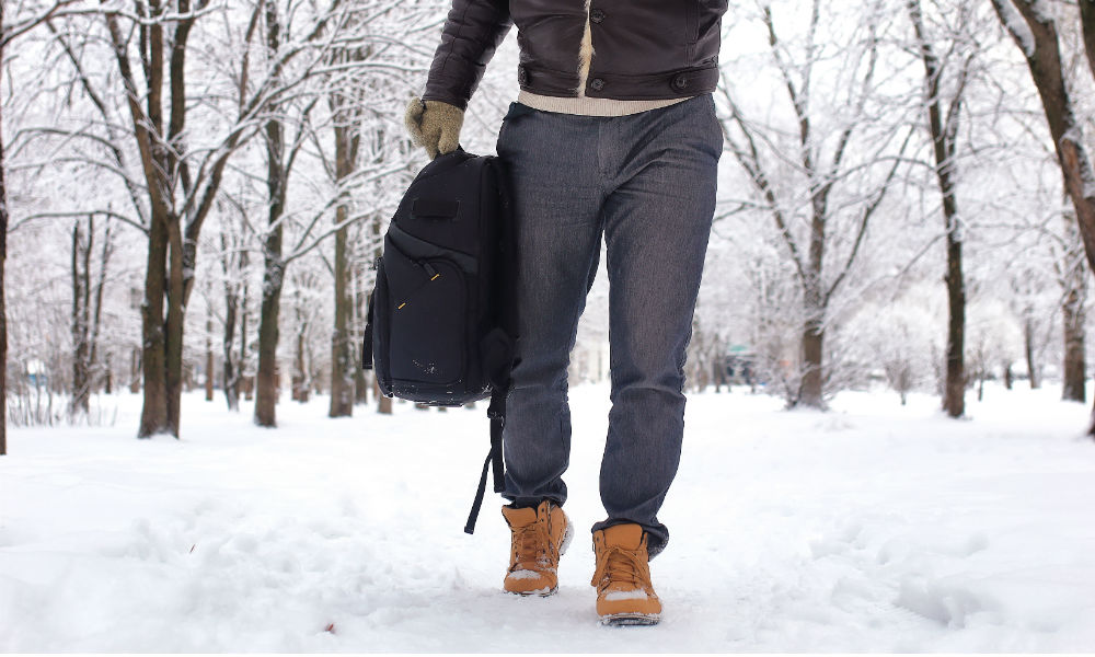 man-walking-through-snow-with-backpack