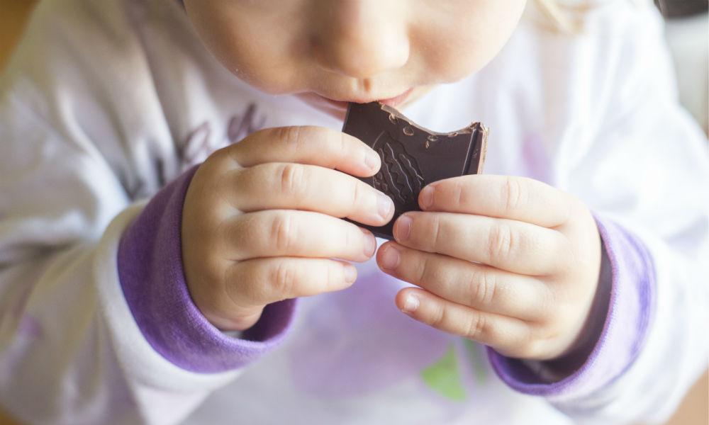 small child is eating chocolate