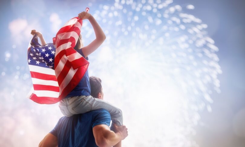 Father and son waving American flag