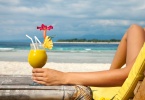 woman enjoying a cocktail on a caribbean beach