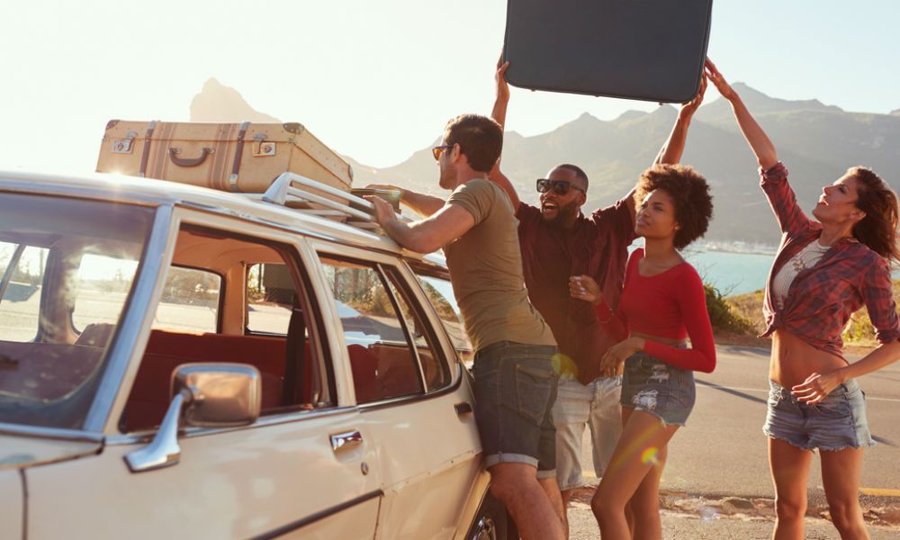 group of friends packing a car for a road trip