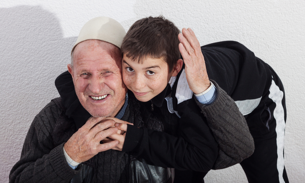 smiling grandfather embracing nephew