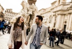 Casual young couple holding hands walking in Rome, Italy, Europe.