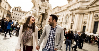 Casual young couple holding hands walking in Rome, Italy, Europe.