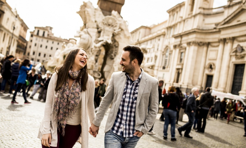 Casual young couple holding hands walking in Rome, Italy, Europe.