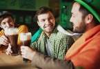 friends drinking guinness at a bar on st. patrick's day in ireland