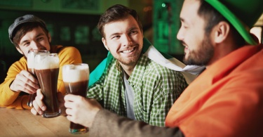 friends drinking guinness at a bar on st. patrick's day in ireland