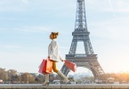 woman walks beside eiffel tower in paris