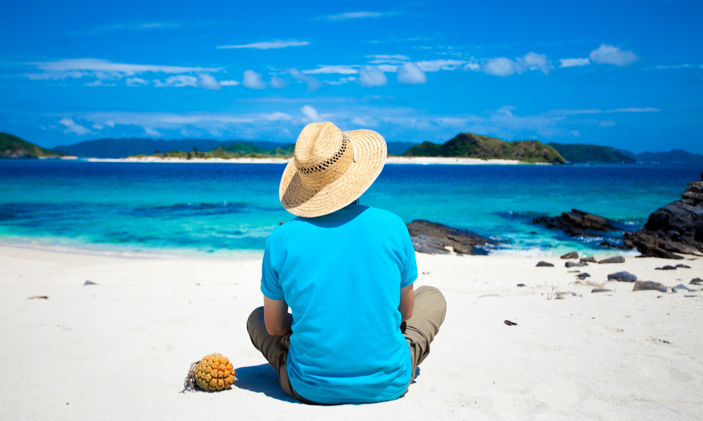 Man looking at coral island on the horizon