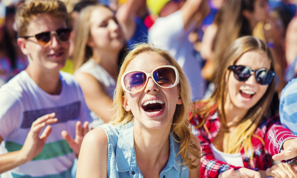 Group of beautiful teens at concert at summer festival