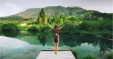 young-woman-stands-on-wooden-bridge