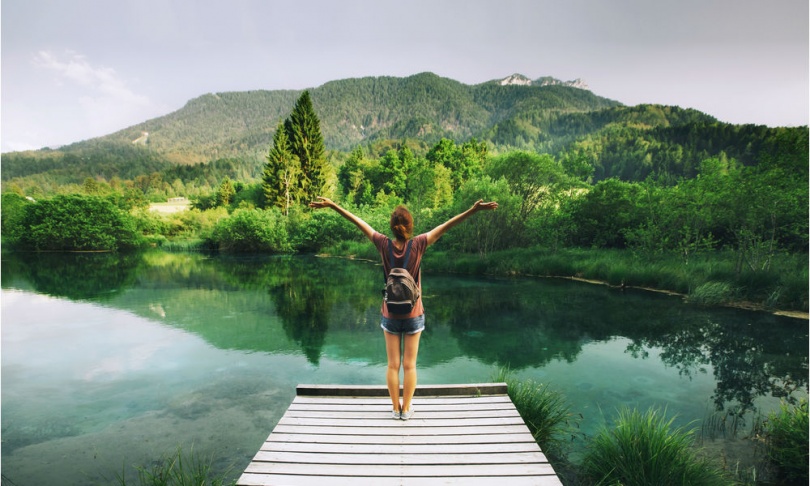 young-woman-stands-on-wooden-bridge