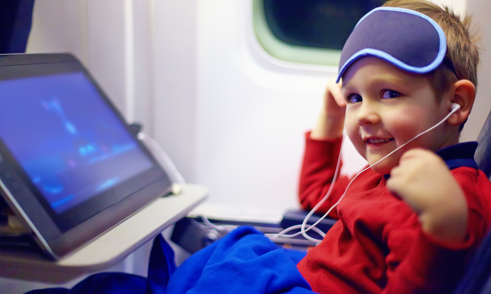 cute little kid watching cartoons during the long flight in airplane