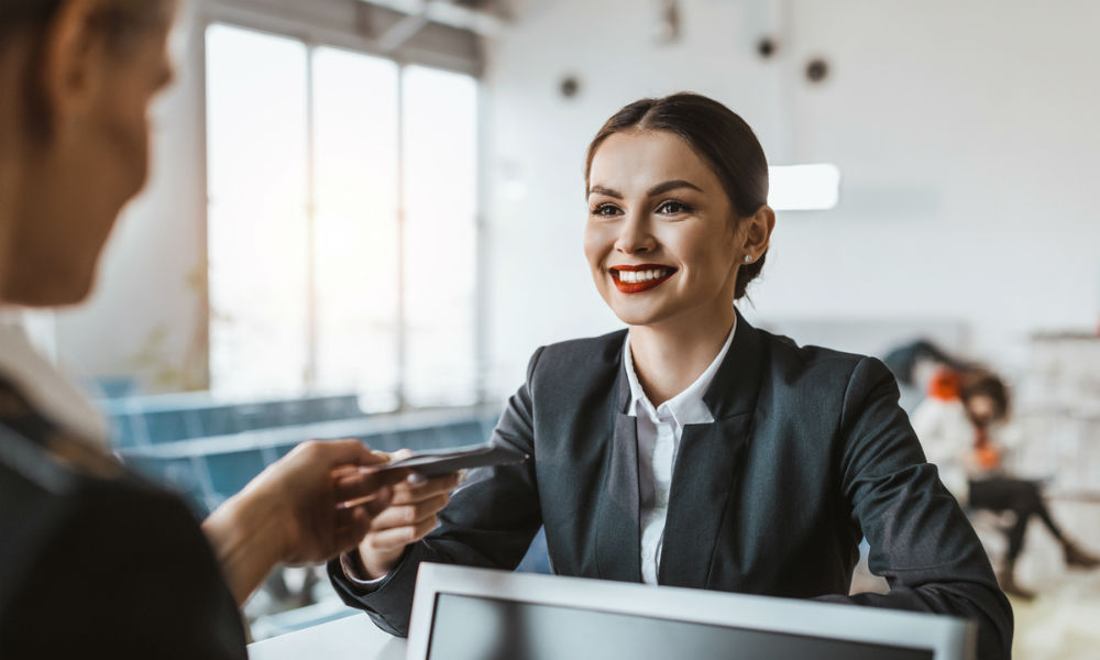 attractive young businesswoman giving passport and ticket to staff at airport check in counter