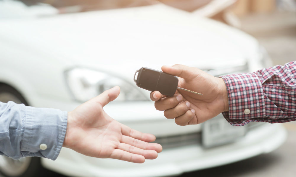 exchange handing over the car keys for to a young businessman.