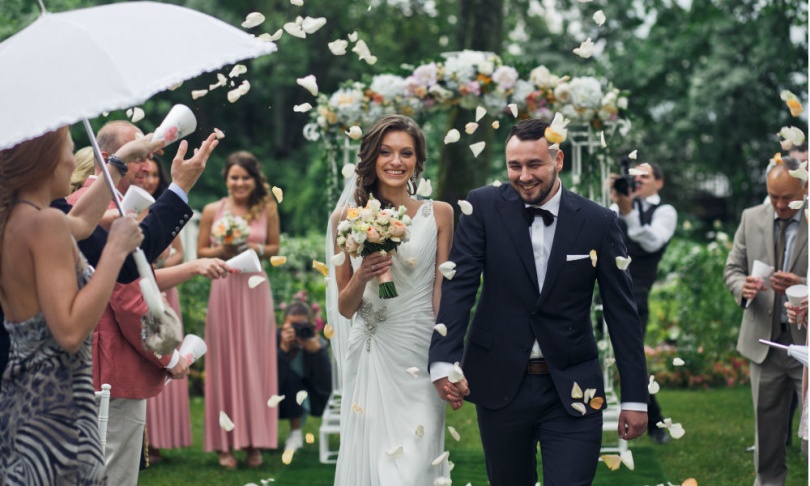 Newlyweds and rose petals in the air