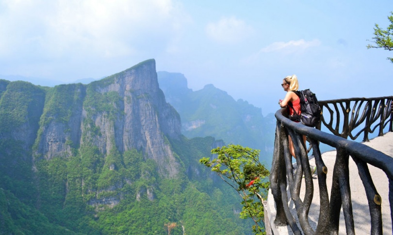 a female solo traveler looks at mountain view in China