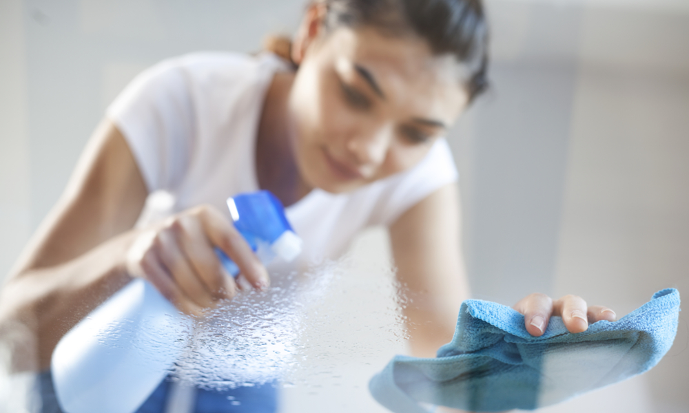 woman cleaning glass table