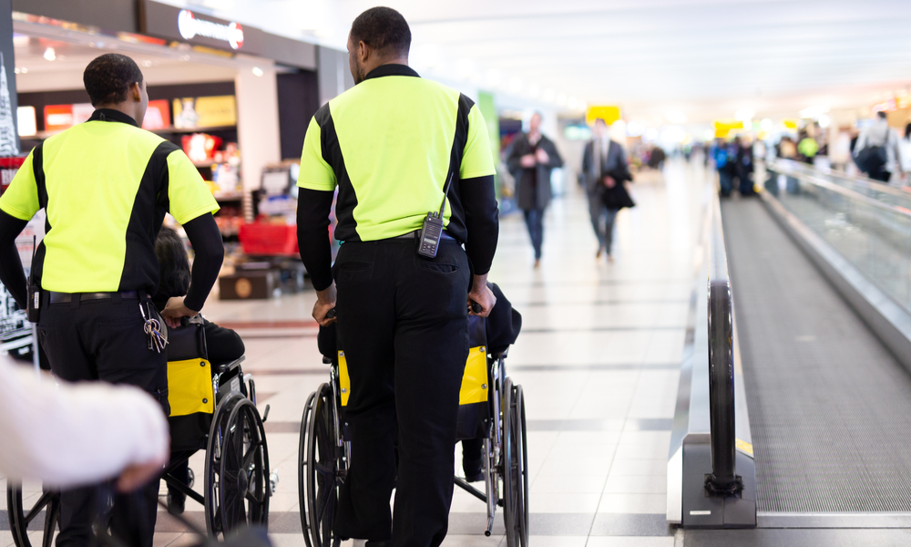 Man caretaker pushing elderly people in wheelchair in the airport