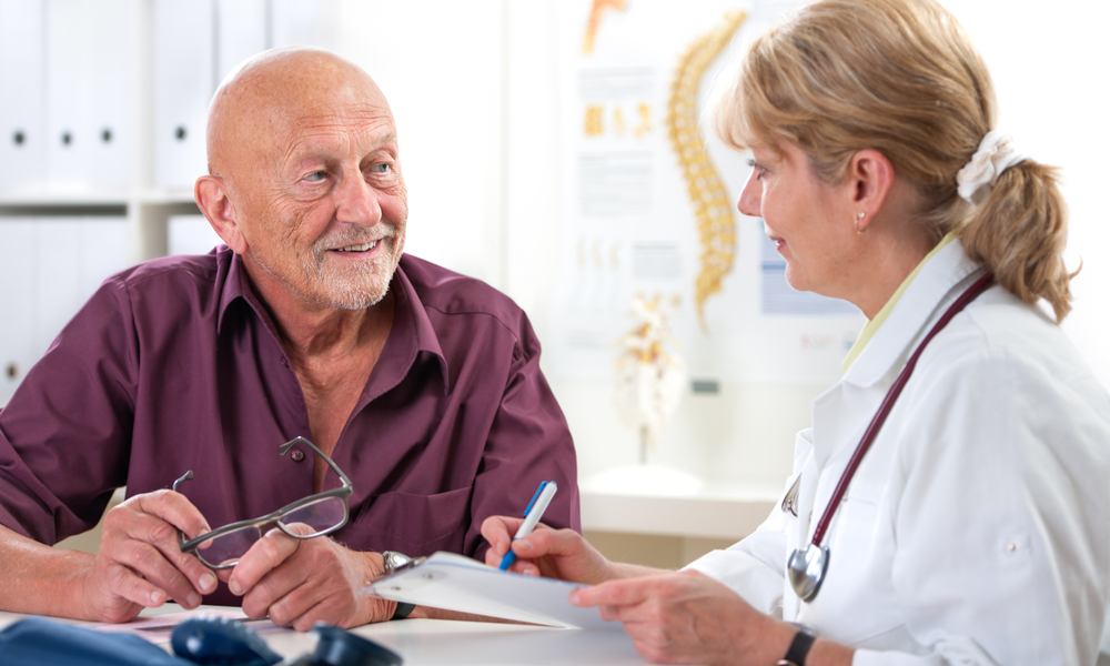 doctor talking to her male senior patient at office