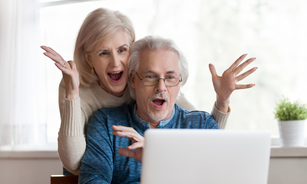 Excited senior mature couple surprised by good unbelievable deals online