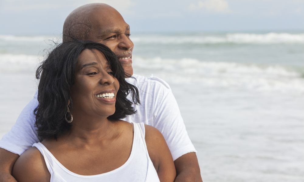 Happy romantic senior African American man and woman couple on a deserted tropical beach