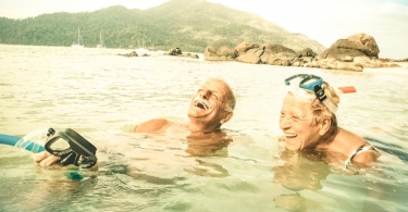 Senior couple vacationer having genuine fun on tropical Koh Lipe beach in Thailand