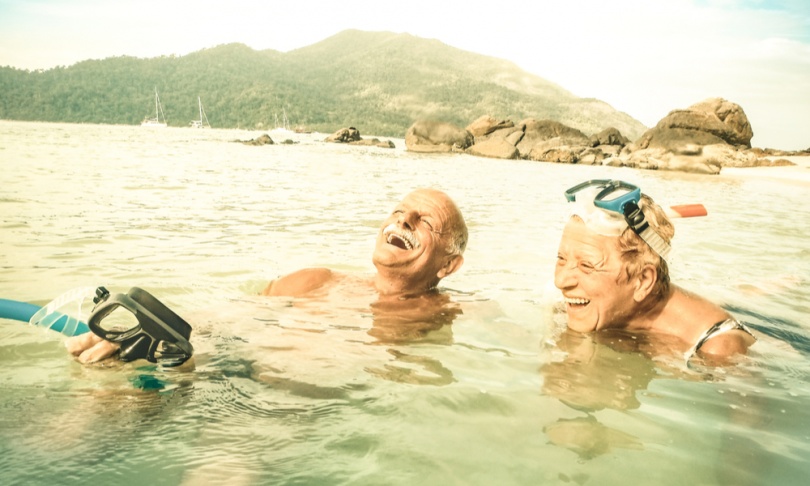 Senior couple vacationer having genuine fun on tropical Koh Lipe beach in Thailand