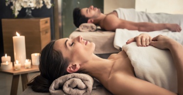 Young man and woman lying down on massage beds at Asian luxury spa and wellness center