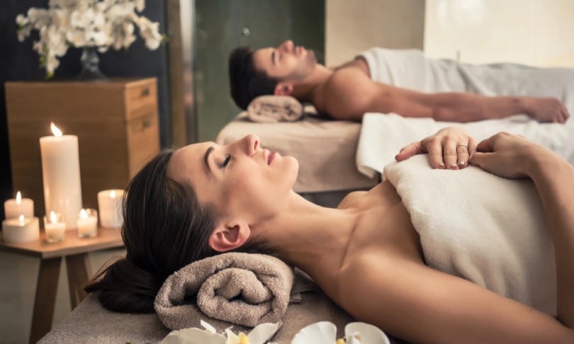 Young man and woman lying down on massage beds at Asian luxury spa and wellness center