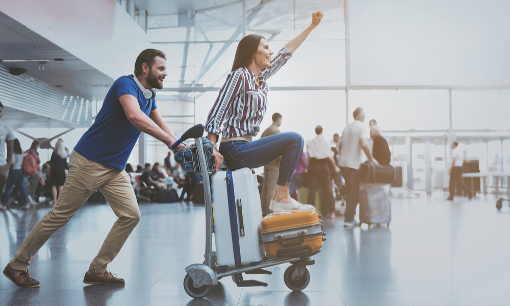 Hilarious smiling couple playing at terminal