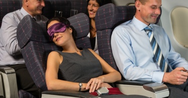 Business woman sleep during night flight airplane cabin passengers