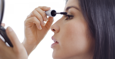 woman putting on mascara