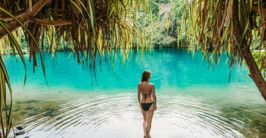 A young woman in blue lagoon in Jamaica