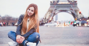 young smiling happy beautiful woman tourist in Paris looking at camera