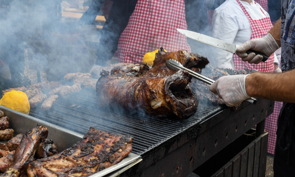 The best U.S. food festivals you have to visit: Chef hands cooking a very large piece of meat on the grill.