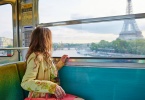 best day trips from paris: Beautiful young woman travelling in a train of Parisian underground and looking through the window at the Eiffel tower