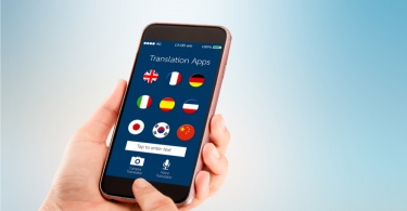 The Best Translation App for Your Travel Plans: mobile translation application concept.Hand holding mobile phone on blurred abstract backgrounds