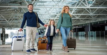 save money flying for the holidays - family in the airport