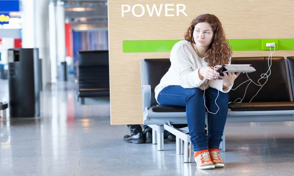 woman avoids winter flying mistakes by charging phone at airport