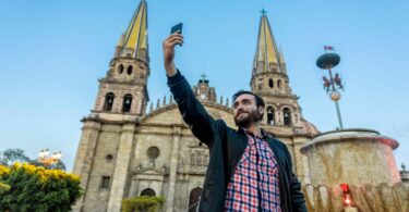 Tourist taking a selfie with his cell phone in the Cathedral in the city of Guadalajara