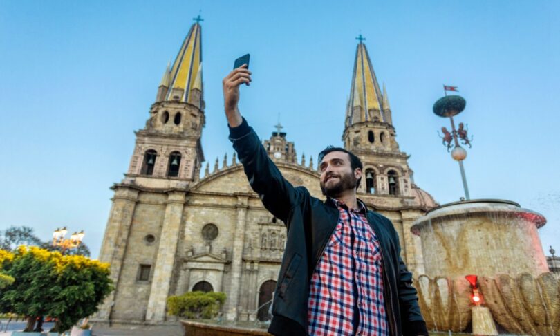 Tourist taking a selfie with his cell phone in the Cathedral in the city of Guadalajara